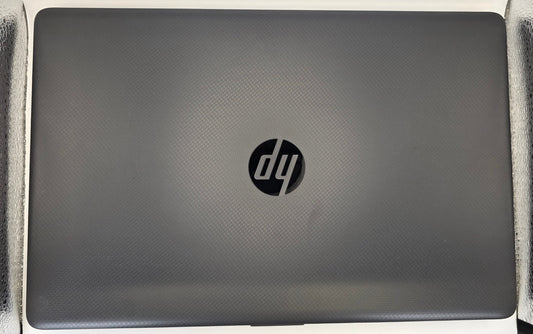 A closed HP laptop in a dark gray finish, positioned vertically on a textured silver surface against a white background.